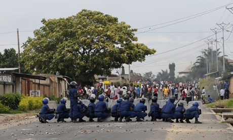 Burundi riot police face stone throwing demonstrators  during clashes in the Musaga district of Bujumbura, Burundi, Tuesday April 28, 2015. Anti-government street demonstrations continued for a third day after six people died in protests against the move by President Pierre Nkurunziza to seek a third term. (AP Photo/Jerome Delay)