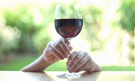 Little hands holding stem of wine glass