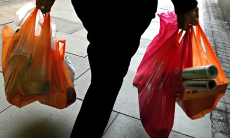 A woman carries her shopping in plastic bags