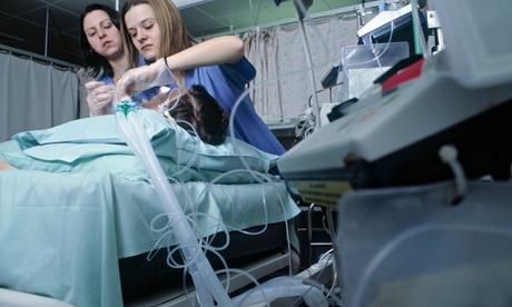 Spanish nurses put a patient on oxygen in an intensive care unit at an NHS hospital in Blackburn. Photograph: John Angerson /Alamy