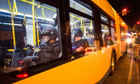Riot police are brought in on a public bus to monitor protests in Baltimore.