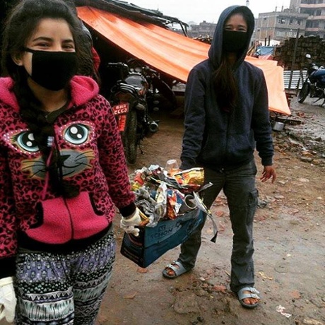 Girls from the orphanage clearing rubbish