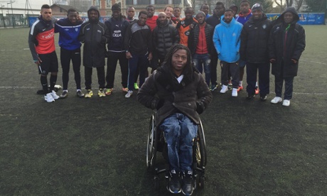 Ade Adepitan stands with the players of St Denis in Unreported World.