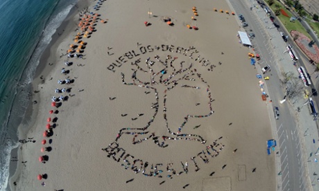 Activists form a human banner on Agua Dulce beach in Lima, with the words ‘Indigenous people+rights – living forests’.