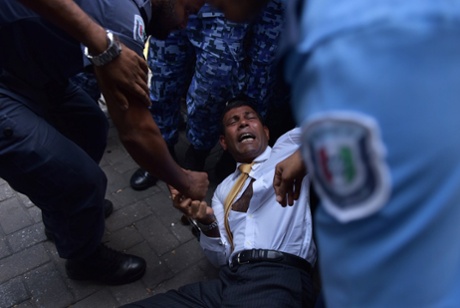 Maldives police try to move former president Mohamed Nasheed as he arrives at court in Male.