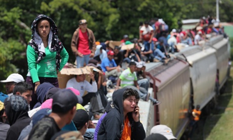 Central American immigrants ride north on top of a freight train, known as 'la bestia', near Juchitan, Mexico.