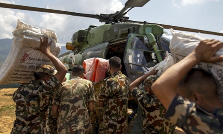 Nepalese military load aid supplies onto an Indian helicopter in Gorkha.