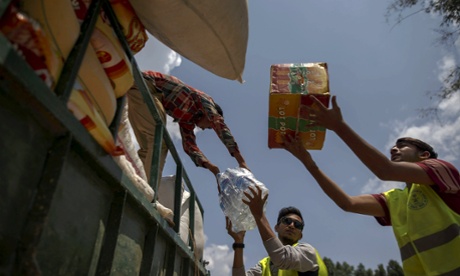 Volunteers unload relief supplies from a truck at Asslang village, in Gorkha.