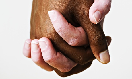 Black and white hands grasping each other