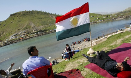 Kurdish Iraqis rest under a Kurdish flag by the river during the Persian Nowruz celebrations in Dukan near the city of Suleymaniyah, in Kurdish dominant northern Iraq.