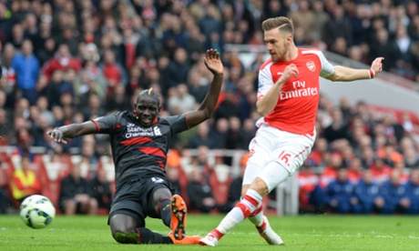 Now it's Aaron Ramsey's turn to shoot and force a save from Simon Mignolet. .