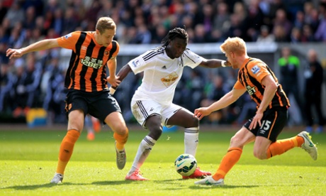 Not content with scoring an acrobatic goal, Swansea City's Bafetibis Gomis leads Hull City's Michael Dawson, left, and Paul McShane on a merry dance.