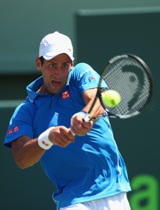 Novak Djokovic plays a backhand.