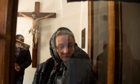 A woman attends mass.