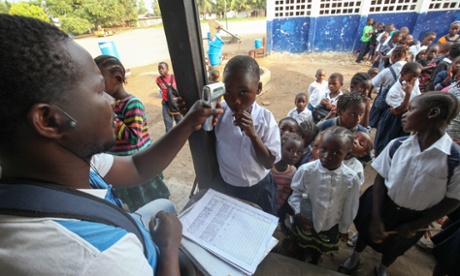 A Liberian health worker examines the temperature of students to curb the spread of Ebola in Caldwell, outside the capital Monrovia.