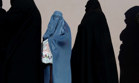 Afghan women line up to receive winter supplies at a UNHCR distribution centre for needy refugees at the Women's Garden in Kabu on January 2, 2013.