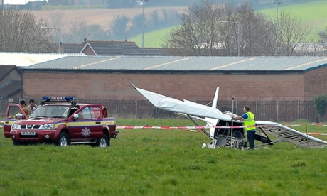 Police and fire crew at the scene in Newtownards, Co Down. The two-seater microlight aircraft crash-landed just off the runway.