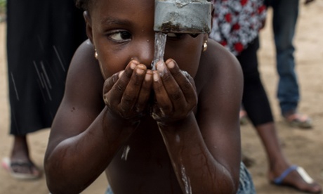 A child drinks some water at a newly sunk borehole, dug using a manual drill at a village in the west districts of Kinshasa so that  women and childrens do not have to walk long distances to reach small and often polluted river on march 7, 2015. Drilling of wells by hand is a common technique in rural D.R. Congo, a technique 4-5 time cheaper than the classic one and can be operated in remote areas where it would be near impossible to bring the materials for mechanical drilling.