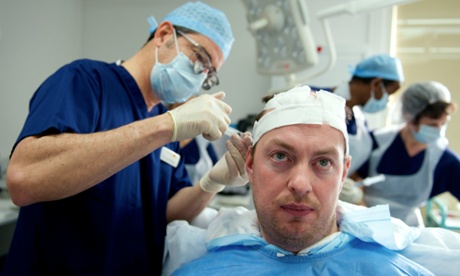 Surgeon Greg Williams performing a hair transplant on Michael Pulman.