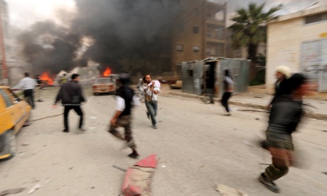 A man runs with an injured child during alleged shelling by Syrian government forces in Idlib city.