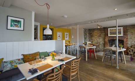 Wooden chairs and tables with a hanging lamp at Brassica