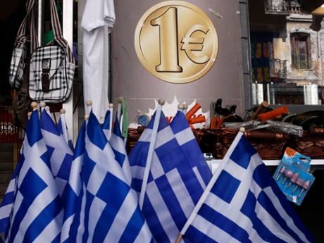 Greek national flags are displayed for sale at the entrance of a one euro shop in Athens, Greece.