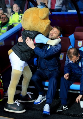 Aston Villa manager Tim Sherwood is hugged by the Aston Villa Club mascot Hercules Lion.