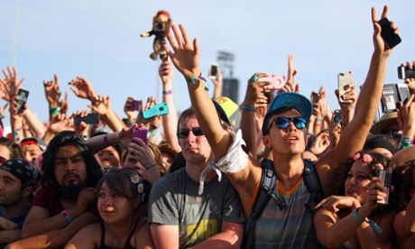 Revellers raise their phones.