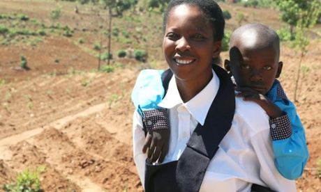 Young tea farmer carries her son on her back
