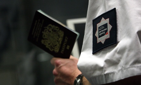 A UK Border Agency officer checks a passport in the north terminal of Gatwick airport.