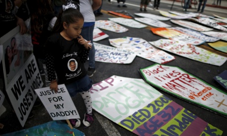 The five-year-old daughter of Jose de la Trinidad, 36, who was fatally shot by Los Angeles County sheriff's deputies, looks at cardboard coffins to commemorate the more than 617 people march organizers say have been killed by law enforcement in LA County since 2000, in Los Angeles, California April 7, 2015. REUTERS/Lucy Nicholson:rel:d:bm:GF10000051992