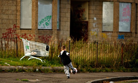 child playing football in rundown street