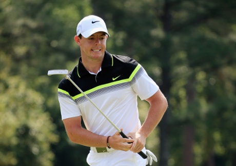 Rory McIlroy warms up with a put on the first green.