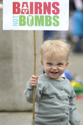 A young child with a placard that reads 'Bairns [babies] not bombs' at a rally against Trident in Glasgow. The SNP's Nicola Sturgeon said: 'We will not vote for anything that facilitates the renewal of Trident.'