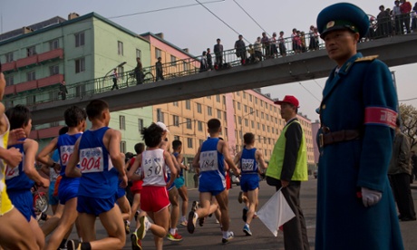 Runners pass under a pedestrian bridge in central Pyongyang. North Korea