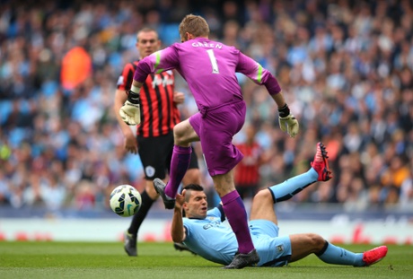 Robert Green clears the ball under pressure from Sergio Aguero.