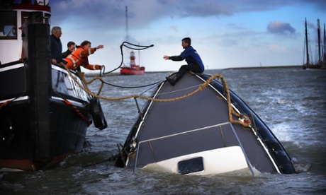 Rescuers try to save a sinking ship in the harbour of Harlingen in northern Netherlands, 22 October 2014
