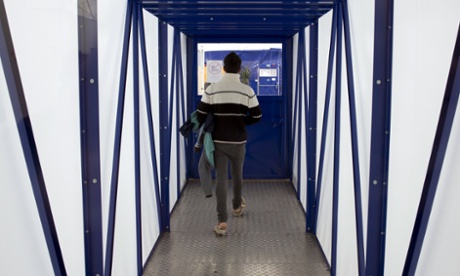 An asylum seeker walks between emergency accommodation shelters for applicants awaiting refugee status in Berlin.