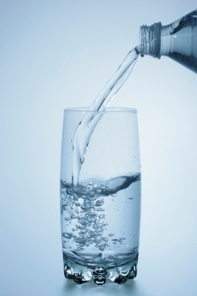 Bottle pouring water into glass