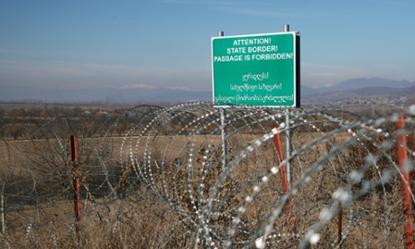 The razor wire along the claimed border - with a sign in Georgian and English.
