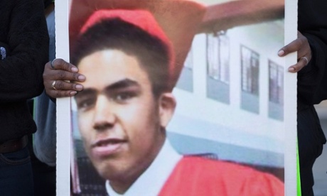 A family member holds a picture of Tony Robinson during a  protest outside of the City Hall building on 9 March.