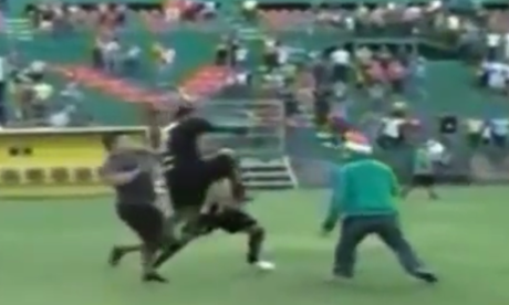 Marlon Peña, the Real España right-back, runs and kicks an opposing fan in the head