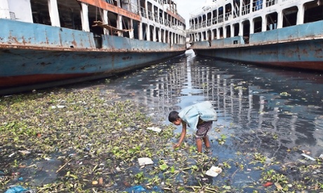 Child picking rubbish from the sea