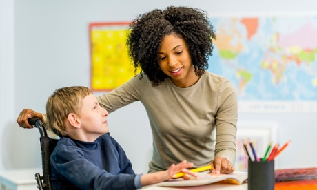 Female professional supervising young disabled boy