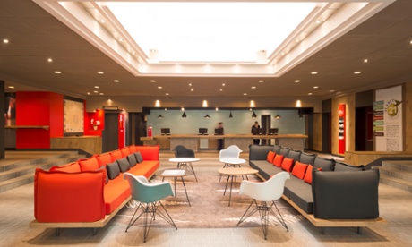 Lobby of the Ibis hotel in Milan, with two long sofas, some plastic chairs and small tables