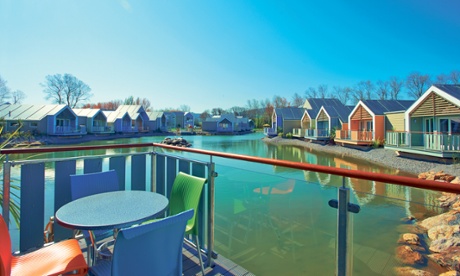 Wooden cottages facing water at the Butlins Westlake Village in Minehead