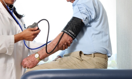 Doctor checks man's blood pressure.