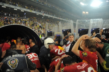 Turkish policemen protect Galatasaray's players after their victory over Fenerbahce at the end of their  match at Sukru Saracoglu Stadium in Istanbul in May 2012.