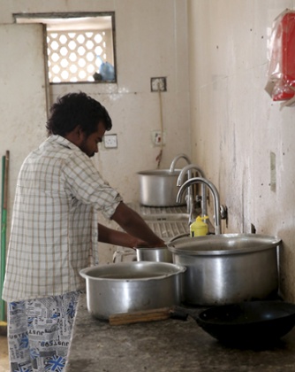 A labourer washes up in a dormitory site in the Sanaya industrial area of Doha.
