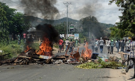 Protesters run near a barricade in Bujumbura in Wednesday.